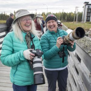 Two women laughing with cameras in hand on a nature photo tour