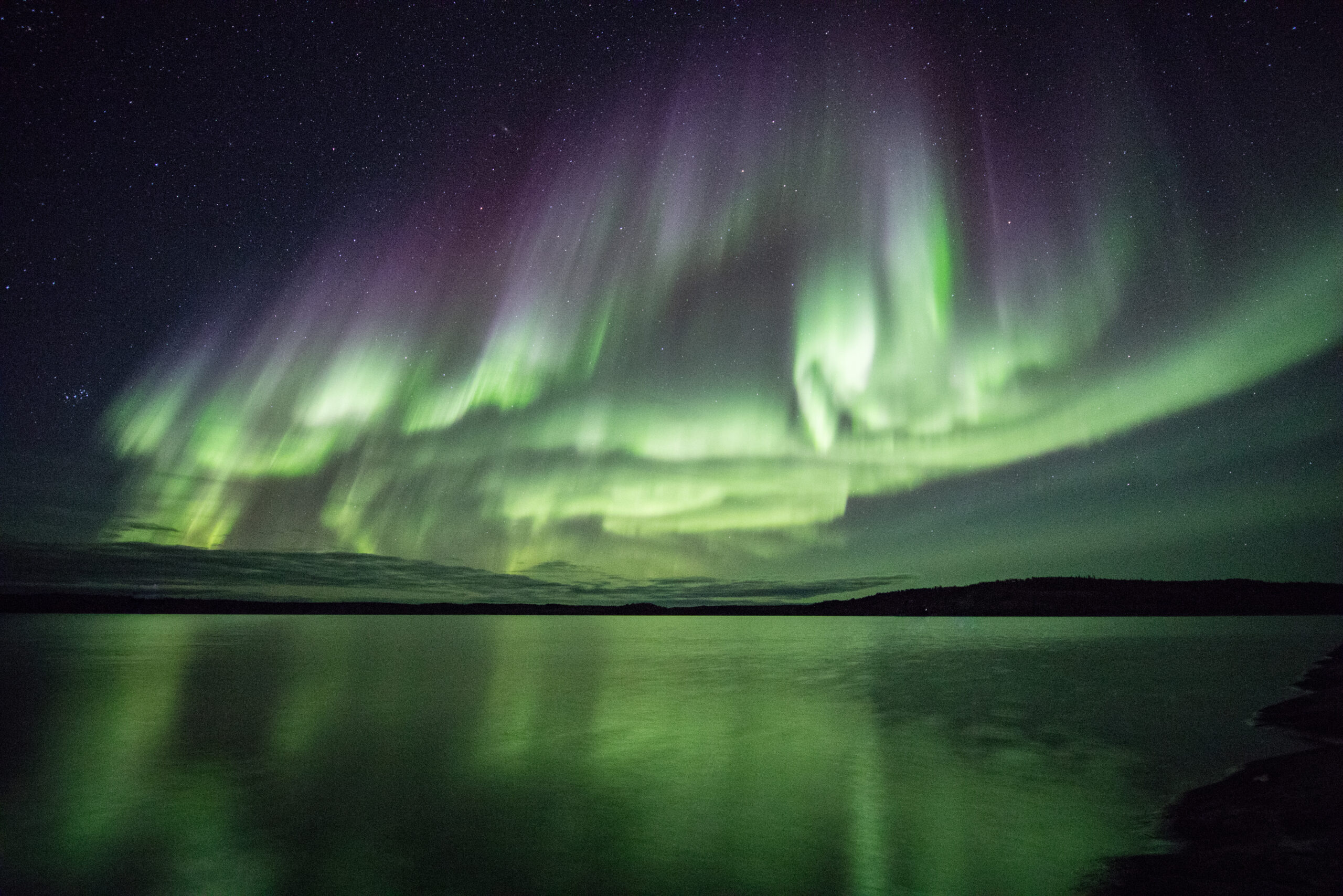 Northern Lights in the autumn with reflections on the waters of Point Lake Northwest Territories