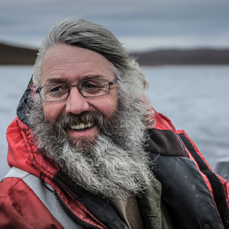 Smiling man in life jacket driving boat