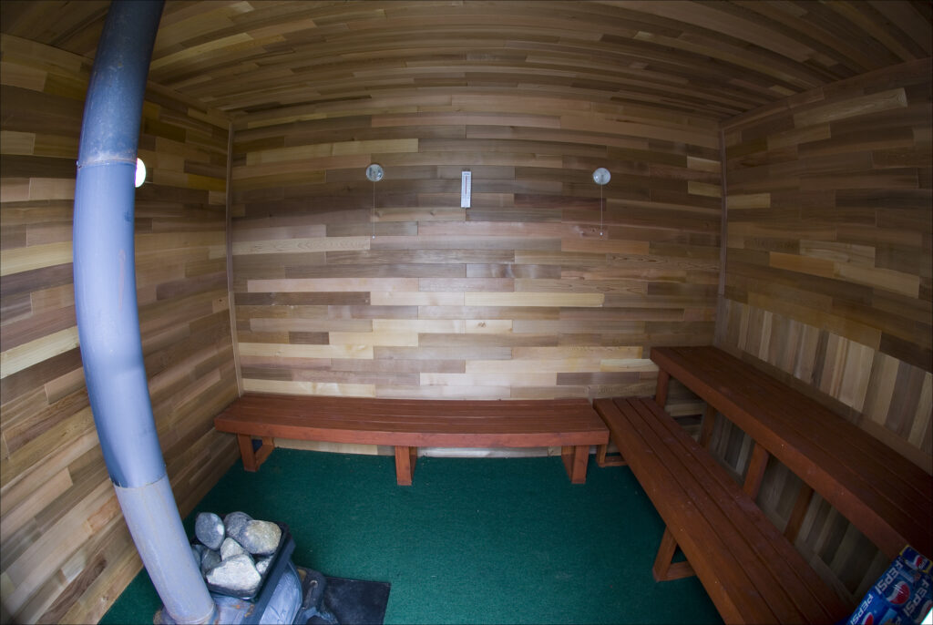 Inside Wood fire Sauna, cedar walls benches and stove