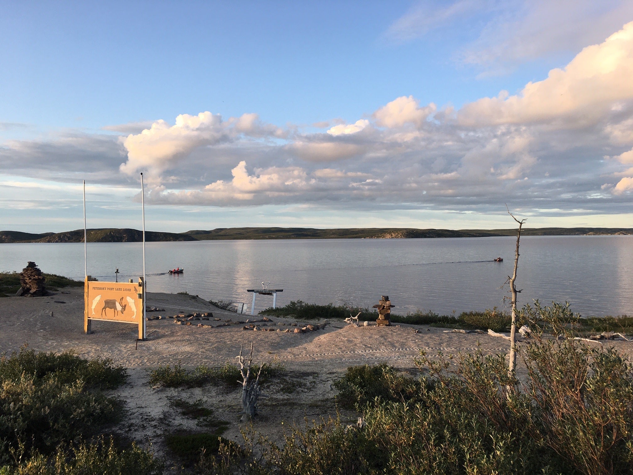 Two boats heading out on a summer evening on Point Lake to go fishing for trophy lake trout in the Northwest Territories Canada