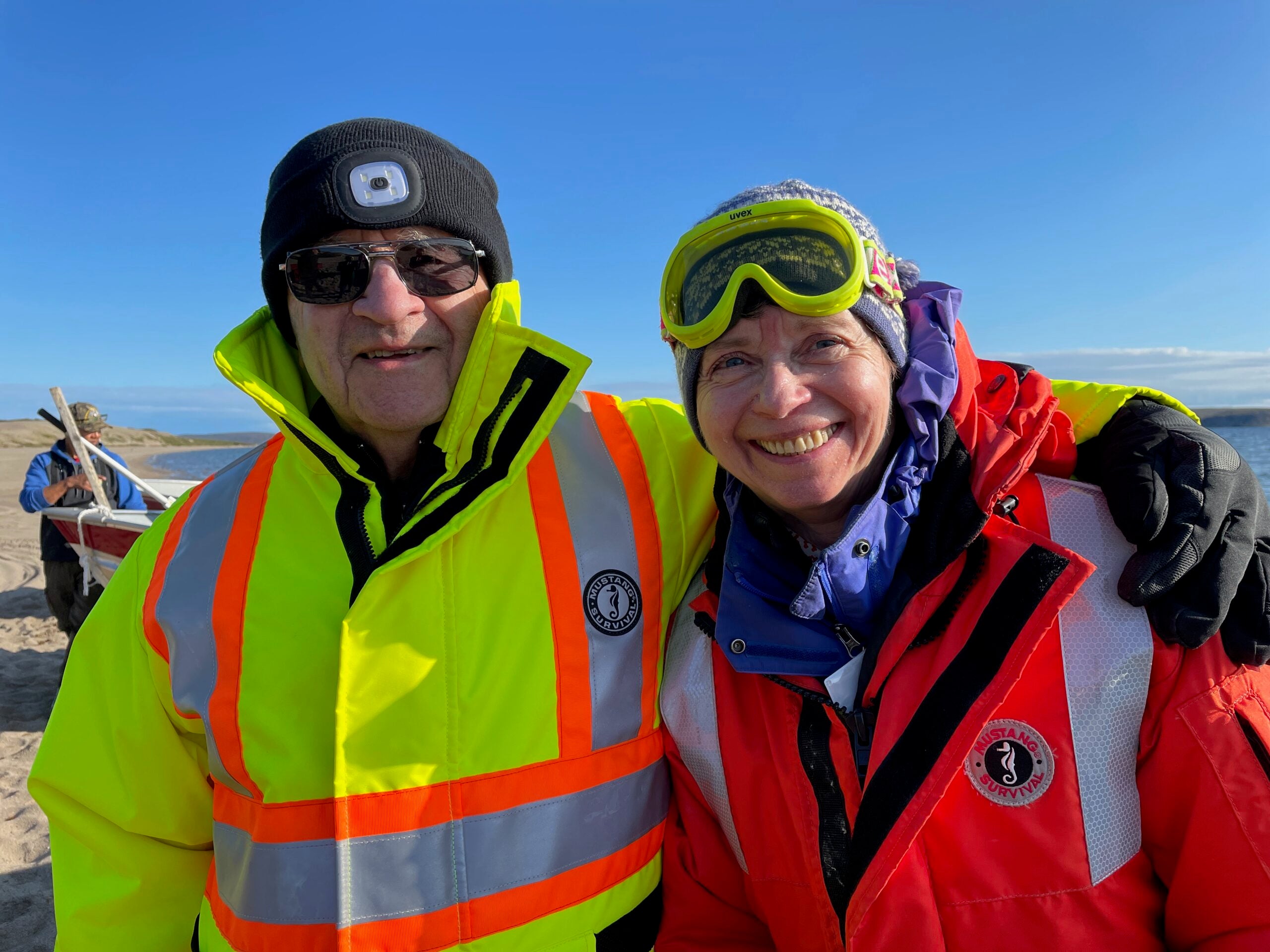 Two very happy people wearing life jackets one with arm wrapped around the other ready for a fun adventure