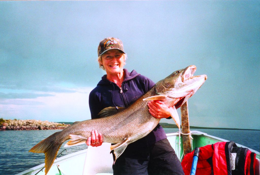 Female Angler holding monster lake trout