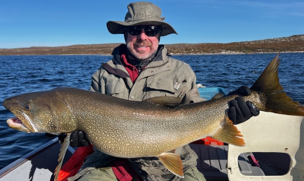 Fisherman holding massive lake trout