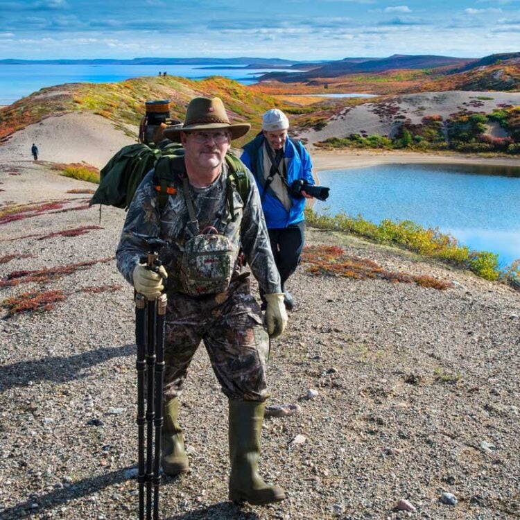 People Hiking on tundra sand esker with fall colours blanketing the landscape