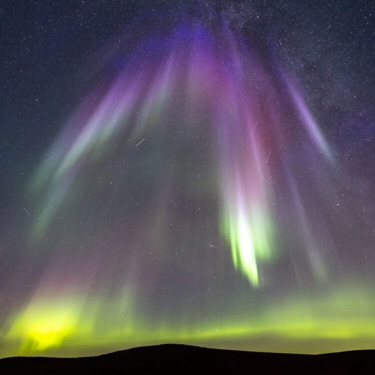 Curtain of green purple and violet aurora dance in the night sky