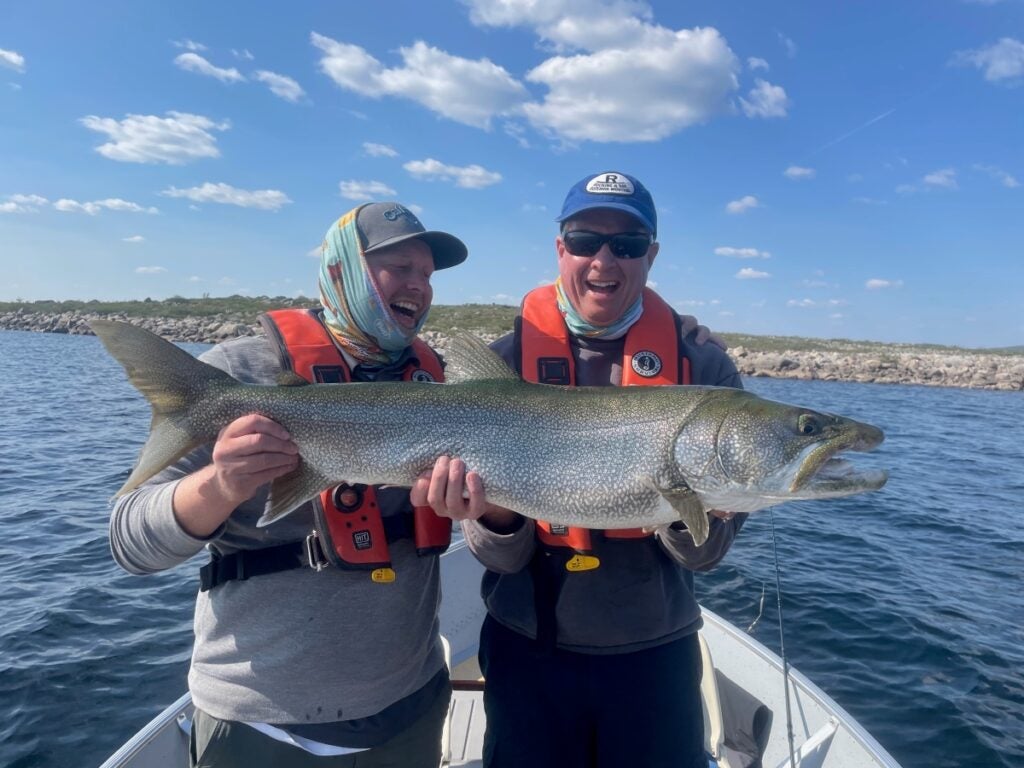 Father and son holding their trophy catch looking incredibly happy 