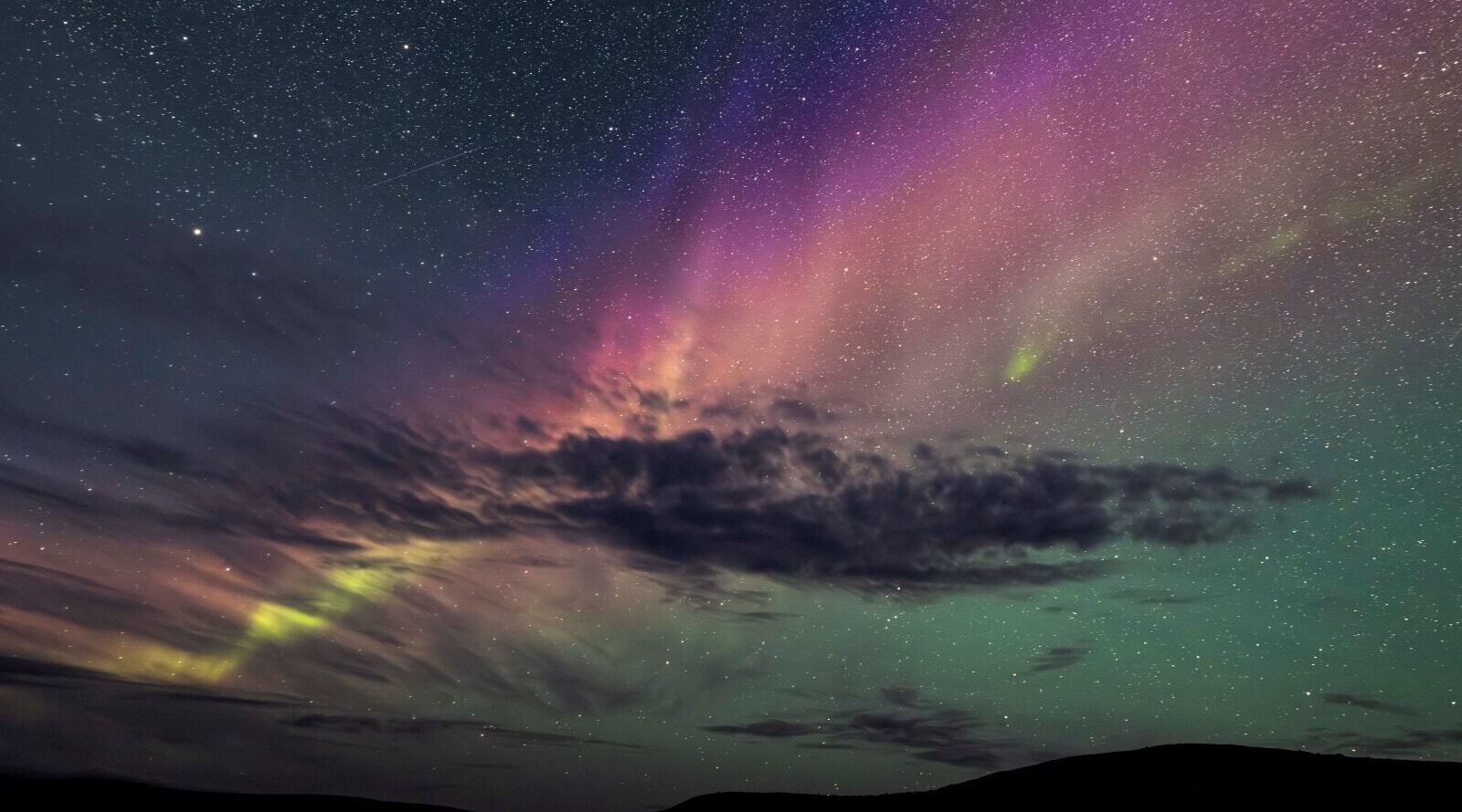 Aurora in vivid colors in autumn, with wisps of clouds