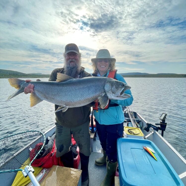 Fishing Guide and lady angler guest with big smiles holding a huge lake trout