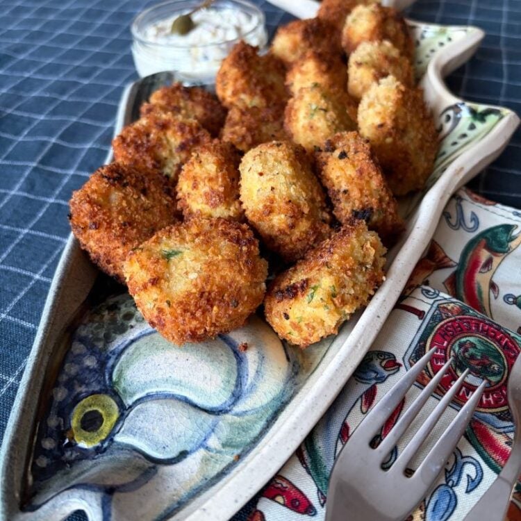 Golden crispy Lake Trout fish cakes on a fish-shaped platter at Peterson's Point Lake Lodge.